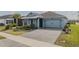 Inviting single-story home with paved driveway, blue siding, and lush green lawn, offering curb appeal at 105 Cerise Ct, Daytona Beach, FL 32124