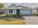 Charming single-story home featuring light blue siding, a two-car garage, and well-manicured landscaping at 105 Cerise Ct, Daytona Beach, FL 32124