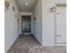 Covered entryway featuring a classic front door, brick flooring, and decorative wall accents at 105 Cerise Ct, Daytona Beach, FL 32124