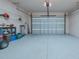 Spacious garage with speckled epoxy flooring, shelving, and an automatic door at 105 Cerise Ct, Daytona Beach, FL 32124