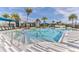 Beautiful community pool with palm trees, lounge chairs and an inviting deck area on a sunny day at 105 Cerise Ct, Daytona Beach, FL 32124