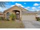 Tan one-story house with a two-car garage and manicured lawn at 10727 Brown Trout Cir, Orlando, FL 32825