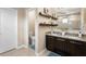 Contemporary bathroom with double vanity featuring granite counters, dark wood cabinets, and decorative shelves at 108 Blanco Dr, Deland, FL 32724
