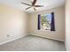 Neutral bedroom with soft carpet, ceiling fan, and window dressed with dark purple curtains at 108 Blanco Dr, Deland, FL 32724