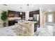 Beautiful kitchen with an island, dark cabinets, stainless steel appliances and gorgeous marble floors at 108 Blanco Dr, Deland, FL 32724