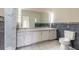 Bathroom featuring double sinks, marble tiling, vanity lighting and a large mirror at 1195 10Th St, Daytona Beach, FL 32117