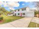 Two-story home with bright red front door and a long driveway, showcasing its curb appeal at 1195 10Th St, Daytona Beach, FL 32117