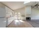 Bright kitchen with white cabinets, appliances, and tile flooring, featuring a fireplace, ceiling fan, and natural light at 1195 10Th St, Daytona Beach, FL 32117