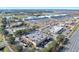 An aerial view showcasing a shopping center with ample parking space, surrounded by commercial buildings and roads at 1372 Lombardi Ct, Poinciana, FL 34759