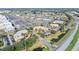 A stunning aerial view of a busy shopping center with a parking lot surrounded by ponds and roads in a bustling neighborhood at 1372 Lombardi Ct, Kissimmee, FL 34759