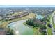 Scenic aerial view showcasing residential homes, a golf course, and a tranquil lake at 1372 Lombardi Ct, Poinciana, FL 34759
