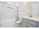 Bright bathroom showcasing tile floors, modern sink, and tub with shower at 1372 Lombardi Ct, Poinciana, FL 34759
