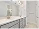 Modern bathroom featuring double sinks, granite countertops, gray cabinets, and a glass-enclosed shower at 1372 Lombardi Ct, Poinciana, FL 34759