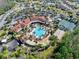 Stunning aerial view of the community clubhouse featuring a pool, tennis courts, and lush landscaping at 1372 Lombardi Ct, Poinciana, FL 34759