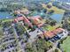 Aerial view of community clubhouse featuring pools, lakes, palm trees, and multiple buildings at 1372 Lombardi Ct, Kissimmee, FL 34759