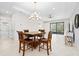 Spacious dining room featuring tile floors, modern chandelier, large windows, and wood dining table with chairs at 1372 Lombardi Ct, Poinciana, FL 34759