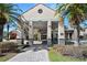 Welcoming entrance to the building with stone pillars, landscaping, and covered walkway at 1372 Lombardi Ct, Poinciana, FL 34759