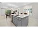 Modern kitchen featuring an island with a sink, light gray cabinets and drawers and stainless steel appliances at 1372 Lombardi Ct, Poinciana, FL 34759