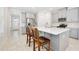 Open kitchen features gray cabinets, stainless steel appliances, and a large island at 1372 Lombardi Ct, Poinciana, FL 34759