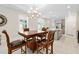 Spacious kitchen and dining area with a modern chandelier, light gray cabinets, white counters and stainless appliances at 1372 Lombardi Ct, Poinciana, FL 34759