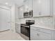 The kitchen features gray cabinets, stainless steel appliances and a large island at 1372 Lombardi Ct, Poinciana, FL 34759