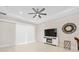 Bright living room featuring tile floors, a modern ceiling fan, a large flat-screen TV and sliding glass doors at 1372 Lombardi Ct, Poinciana, FL 34759