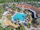 Aerial view of the resort-style pool featuring lots of seating, umbrellas, and lush landscaping at 1372 Lombardi Ct, Poinciana, FL 34759
