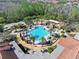 Aerial view of the resort-style pool with ample seating and beautiful palm trees at 1372 Lombardi Ct, Poinciana, FL 34759