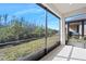 A large screened-in patio with a view of the private backyard at 1372 Lombardi Ct, Poinciana, FL 34759