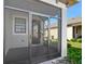 View of the screened-in front porch featuring custom door and tile flooring at 1372 Lombardi Ct, Poinciana, FL 34759