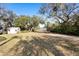 Sprawling backyard boasting mature trees, a storage shed, and a pathway leading to the serene lake at 149 Sheryl Dr, Deltona, FL 32738