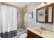 Cozy bathroom showcasing a shower with tub, and a vanity cabinet with framed mirror and decorative art pieces at 149 Sheryl Dr, Deltona, FL 32738