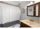 Cozy bathroom showcasing a shower with tub, and a vanity cabinet with framed mirror and decorative art pieces at 149 Sheryl Dr, Deltona, FL 32738