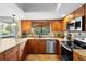 Well-lit kitchen with stainless steel appliances, granite countertops, and wood cabinetry at 149 Sheryl Dr, Deltona, FL 32738