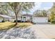 Charming single-story home with a well-manicured lawn, mature tree, and welcoming front entrance at 163 Chrysanthemum Dr, Ormond Beach, FL 32174