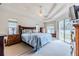 Bright main bedroom featuring a tray ceiling, ceiling fan, and sliding glass door to the backyard at 163 Chrysanthemum Dr, Ormond Beach, FL 32174