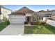 Single-story home with a two-car garage and well-manicured lawn at 164 E Fiesta Key Loop, Deland, FL 32720