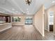 Open living room features tray ceilings, lake views, an island kitchen, and wood-look flooring at 177 Rosedale Dr, Deltona, FL 32738