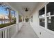 View of the long porch with fans and railing overlooking the lake at 177 Rosedale Dr, Deltona, FL 32738