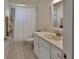 Well-lit bathroom featuring a shower and tub, white vanity, and tile flooring at 2075 Little Farms Ct, Deltona, FL 32738