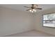 Bright bedroom features neutral carpeting, ceiling fan with light fixture, and large window for natural light at 2075 Little Farms Ct, Deltona, FL 32738