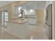 Well-lit kitchen boasts white cabinetry, stainless steel appliances, breakfast bar, and backyard access at 2075 Little Farms Ct, Deltona, FL 32738