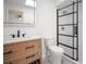 This bathroom features a wood vanity with quartz countertop, sleek black fixtures, and a frameless glass shower enclosure at 24 Sea Gull Dr, Ormond Beach, FL 32176