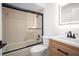 Bright bathroom featuring a modern vanity, illuminated mirror, and a bathtub with a glass enclosure at 24 Sea Gull Dr, Ormond Beach, FL 32176