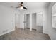 Bright bedroom with ceiling fan, wood-look tile flooring, and a double closet with mirrored doors at 24 Sea Gull Dr, Ormond Beach, FL 32176