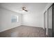 This bedroom has wood-look tile flooring, a ceiling fan, a window, and a mirrored sliding-door closet at 24 Sea Gull Dr, Ormond Beach, FL 32176