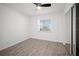 Neutral bedroom features wood-look tile flooring, window overlooking the neighborhood, ceiling fan, and closet with mirrored doors at 24 Sea Gull Dr, Ormond Beach, FL 32176