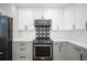 This kitchen features stainless steel KitchenAid appliances, modern two-tone cabinets, and a decorative backsplash at 24 Sea Gull Dr, Ormond Beach, FL 32176