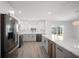 Modern kitchen features stainless steel appliances, sleek cabinetry, a wine fridge, and a large island with a quartz countertop at 24 Sea Gull Dr, Ormond Beach, FL 32176