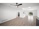 Bright, open-concept living room features wood-look tile flooring, a ceiling fan, and sliding glass doors to the backyard at 24 Sea Gull Dr, Ormond Beach, FL 32176